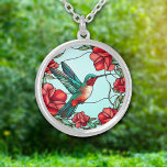 Collier Colibri à fleurs rouges<br><div class="desc">Sur ce joli collier est une image époustouflante d'un colibri à côté d'un groupe de fleurs rouges. Les couleurs du colibri sont le bleu vert et le rouge, qui complètent les images de fleurs et l'arrière - plan bleu ciel clair. Élégant, lumineux et coloré ! Assurez-vous de voir les boucles...</div>