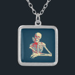 Collier Skeleton rétro<br><div class="desc">Joyeux squelette souriant avec sa main osseuse reposant sur son menton,  réalisé dans des couleurs rétro.</div>