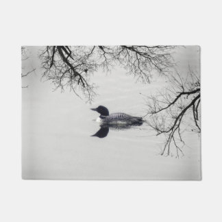 Common Loon zwemt in een noordelijk meer in de win Deurmat