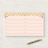 Confettis dorés sur des Post-It rose corail (Sur un bureau)