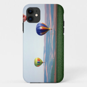 Coque iPhone 11 Des montgolfières colorées flottent au-dessus du