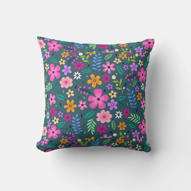 Coussin Art floral (A square throw pillow features a dense, colorful floral pattern against a dark teal background.)