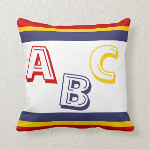 Coussin bleu marine, jaune, et ABC rouge sur le blanc