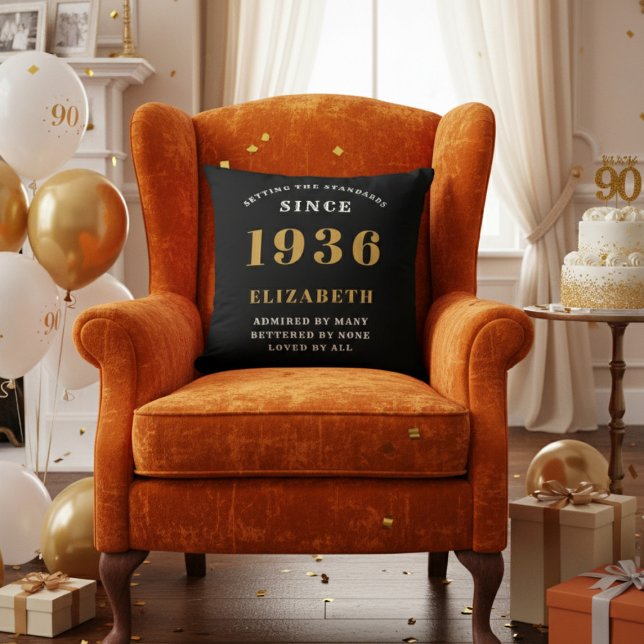 Coussin Cadeau personnalisé 90e anniversaire 1936 Noir Or (A "Since 1936" pillow on an orange velvet armchair in a 90th birthday decorated room)
