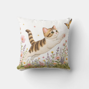 Coussin Chat brodé poursuivant un papillon dans une prairi