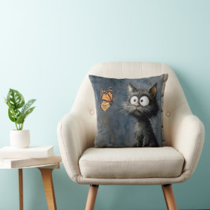 Coussin Chat dépenaillé fixant un papillon