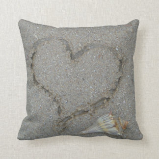 Coussin coeur dans le sable avec coquille