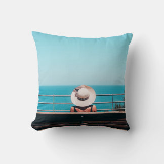Coussin Femme en paille blanche casquette assise sur un ba