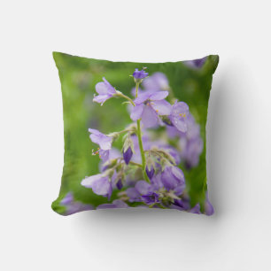 Coussin Fleurs bleues délicates sur un champ vert dans un