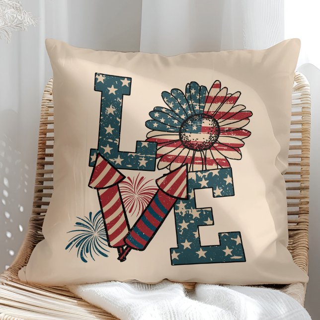 Coussin Jour de l'indépendance du drapeau américain "AMOUR ("LOVE" American Flag Independence Day Throw Pillow in a sunny rattan armchair.)