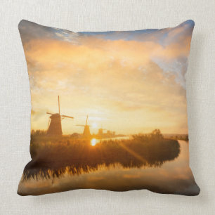 Coussin Lever de soleil sur les moulins à vent et une rivi