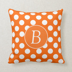 Coussin orange et blanc décoré d'un monogramme d