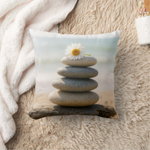 Coussin Pâquerette sur un cairn de plage en pierre avec bo