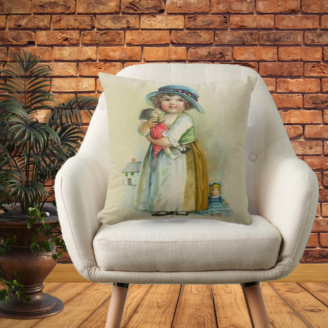 Coussin Petite fille vintage Chubby Cheeks Casquette Poupé (Little girl blue hat holding dolls on tan decorative pillow.)