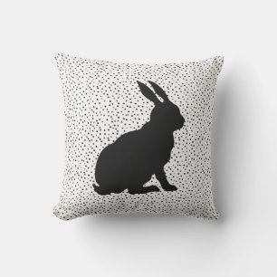 Coussin Silhouette noire assise lapin sur des points noirs