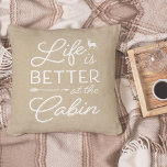 Coussin Tan & White Life est meilleur au Cabine<br><div class="desc">L'oreiller rustique moderne à jetons est orné d'un arrière - plan beige clair et d'un habillage de typographie blanche,  "la vie est meilleure au cabine". Personnalisez l'envers avec votre nom de famille et l'année établie.</div>