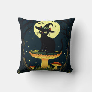 Coussin Un petit chat noir de sorcière assis sur un champi