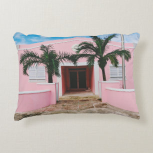 COUSSINS DÉCORATIFS MAISON EN BÉTON ROSE ET BLANC PRÈS DES ARBRES VERT