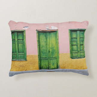 COUSSINS DÉCORATIFS PORTE EN BOIS VERT SUR MUR EN BÉTON BLANC