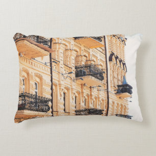 Coussins Décoratifs Une vieille maison jaune aux balcons en fer forgé.