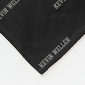 Couverture en polaire noire avec nom gris répétée (Coin)