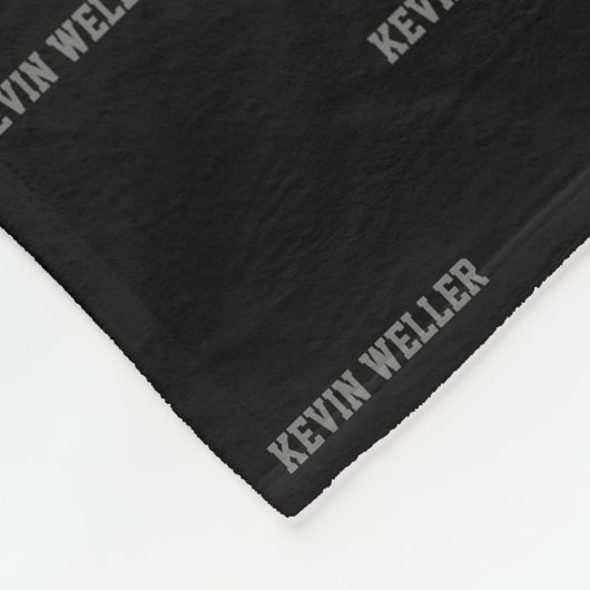 Couverture en polaire noire avec nom gris répétée (Coin)