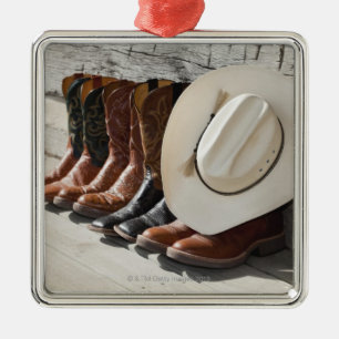 Cowboy pet op rij cowboylaarzen buiten een logboek metalen ornament