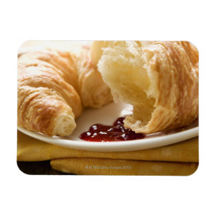 Croissant met jam op een bord magneet