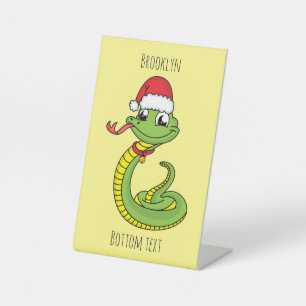 Cute green slang met santa hat cartoon reclamebord met voetstuk
