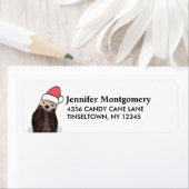 Cute Otter die met Kerstmis een kerstman heeft. Etiket (Insitu)