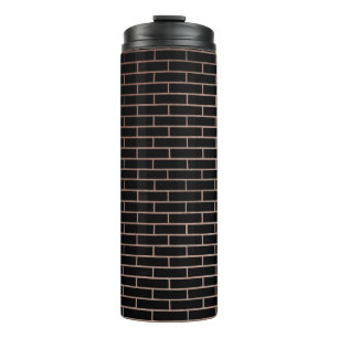 De donkere zwarte muur heeft een ruw oppervlak als thermosbeker