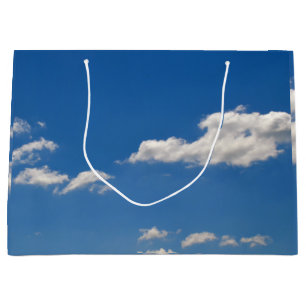 De lucht is blauw en witte wolken trekken voorbij groot cadeauzakje