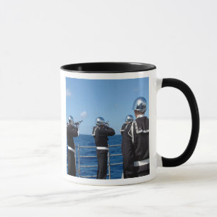 De zeelieden schieten een pistool saluut in tijden mok