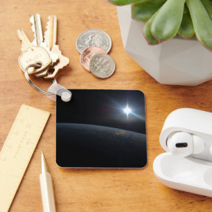 De zon gaat onder aan de horizon van de aarde. sleutelhanger