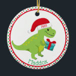 Décoration En Céramique Dinosaure vert avec Santa Hat Personnalisé<br><div class="desc">Le dinosaure vert mignon porte un chapeau de Père Noël rouge et porte un cadeau bleu. Le bord est rouge et vert pois. Personnalisez avec votre nom d'enfant en bas et l'année sur son casquette. Le côté inverse est le même.</div>