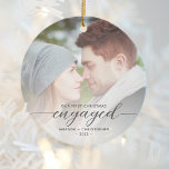 Décoration En Céramique Premier Noël Engagé Photo Grey Script moderne<br><div class="desc">Commémorez votre fiançailles avec ce magnifique ornement de gardien moderne. Le texte en gris fusain dit "Notre premier Noël engagé", avec le mot "engagé" dans un élégant script de calligraphie avec des swashes décoratifs avant et après. Remplacez l'exemple d'image par votre photo préférée, et ajoutez vos noms et l'année. Un...</div>