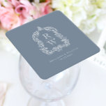 Dessous-de-verre Carré En Papier Noms de crête Monogramme vintage Dusty Blue Mariag<br><div class="desc">Ce design élégant présente une crête ornée, d'inspiration vintage, d'acanthus feuilles encadrant deux initiales monogrammes en police serif ouverte, empilée verticalement et séparée par une fine ligne horizontale. Ajoutez les noms du couple et la date du mariage ci-dessous. Le design et le texte sont en blanc sur un arrière -...</div>