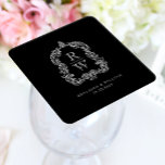Dessous-de-verre Carré En Papier Noms vintages de crêtes de monogramme Mariage noir<br><div class="desc">Ce design élégant présente une crête ornée, d'inspiration vintage, d'acanthus feuilles encadrant deux initiales monogrammes en police serif ouverte, empilée verticalement et séparée par une fine ligne horizontale. Ajoutez les noms du couple et la date du mariage ci-dessous. Le design et le texte sont en blanc sur un arrière -...</div>