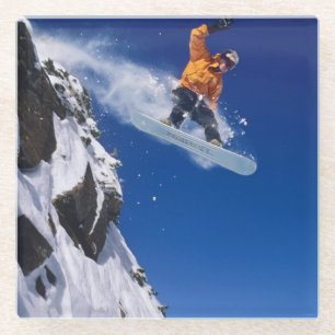 Dessous-de-verre En Verre Homme sur un snowboard sautant d'une corniche