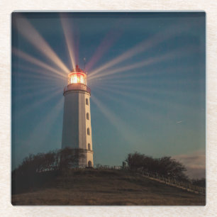 Dessous-de-verre En Verre Phare sur une colline brillant la nuit