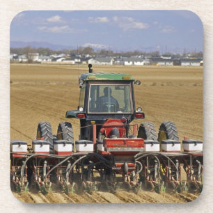 Dessous-de-verre Tracteur tirant un semoir de maïs semence.