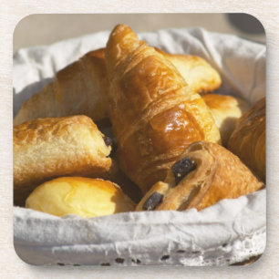 Dessous-de-verre Un panier petit-déjeuner en osier avec croissants