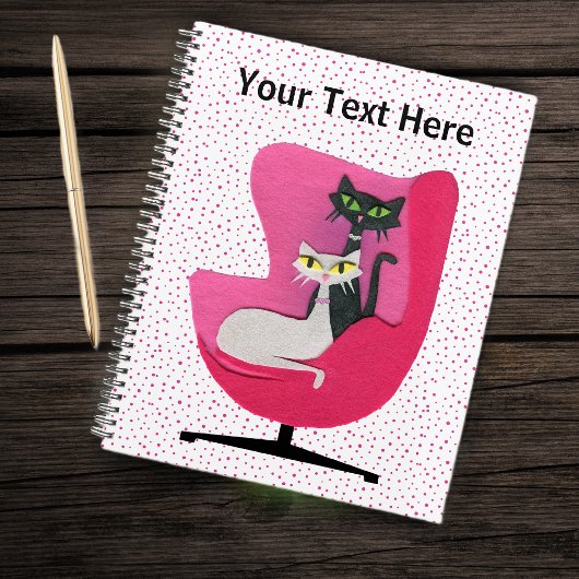 Deux chats assis dans un fauteuil rose milieu du s