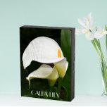 Deux Lys Calla Blanche Floral<br><div class="desc">Panneau de boîte en bois peint en noir conçu pour être accroché ou debout qui présente une photo de deux splendides Lys Calla blancs avec leur feuillage vert. Le texte est imprimé en lettres blanches. Une belle décoration pour la maison !</div>
