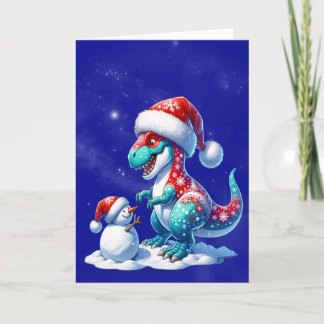 Dinosaur with santa hat building a snowman feestdagen kaart