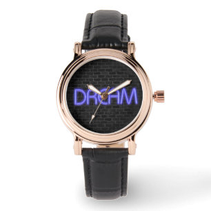 DREAM-tekst in neonverlichting op baksteen Horloge