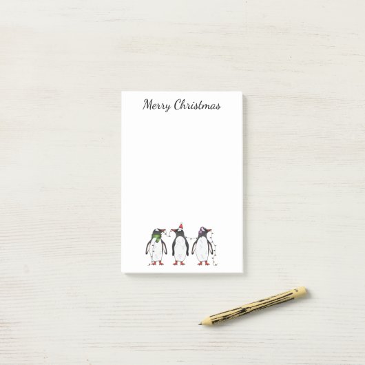 Drie feestelijke kerstpinguïns met aangepaste teks post-it® notes (Op bureau)