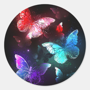 Drie gloeiende vlinders op nachtelijke achtergrond ronde sticker