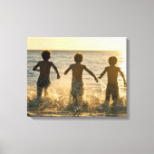 Drie jongens lopen de oceaan in canvas afdruk (Voorkant)