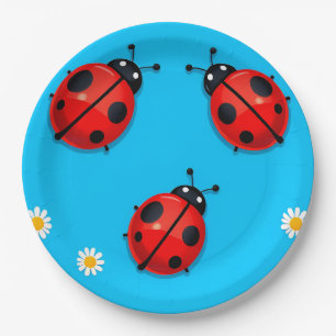 Drie kleurrijke lieveheersbeestjes op blauwe achte papieren bordje